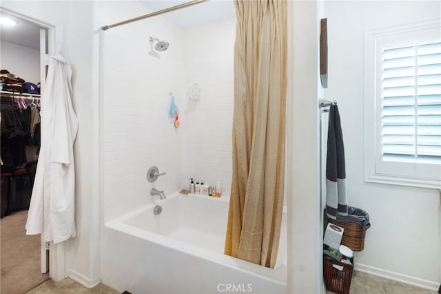 bathroom with shower / bath combo with shower curtain and a healthy amount of sunlight