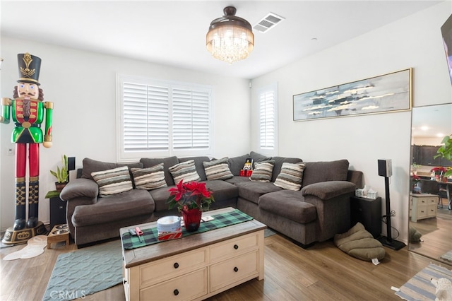 living room with a chandelier and light hardwood / wood-style floors