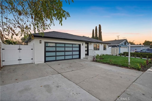 view of front of property with a garage and a lawn