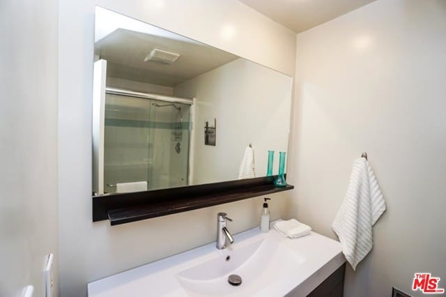 bathroom with vanity and a shower with shower door