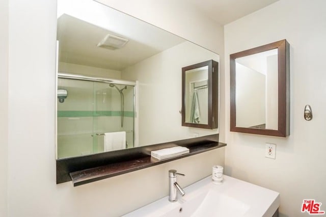 bathroom featuring vanity and an enclosed shower