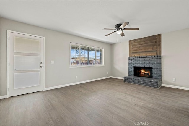 unfurnished living room featuring a fireplace, wood-type flooring, and ceiling fan