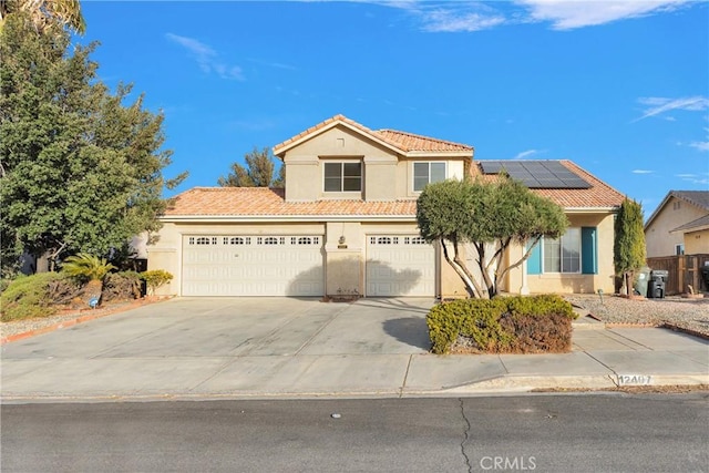 view of front of home featuring solar panels, driveway, a tiled roof, and stucco siding