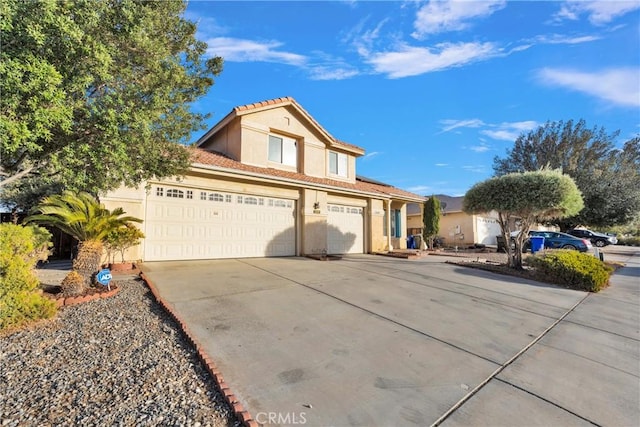 view of front of house featuring driveway, an attached garage, a tiled roof, and stucco siding