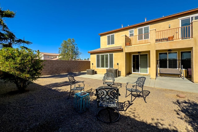 rear view of property with a balcony, central AC, and a patio area