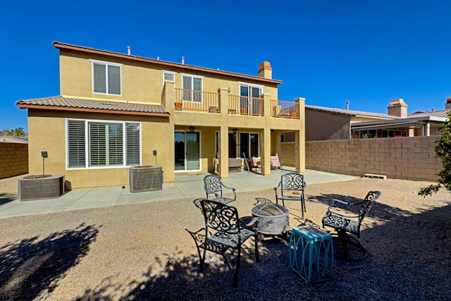 back of house with a balcony, an outdoor fire pit, and a patio