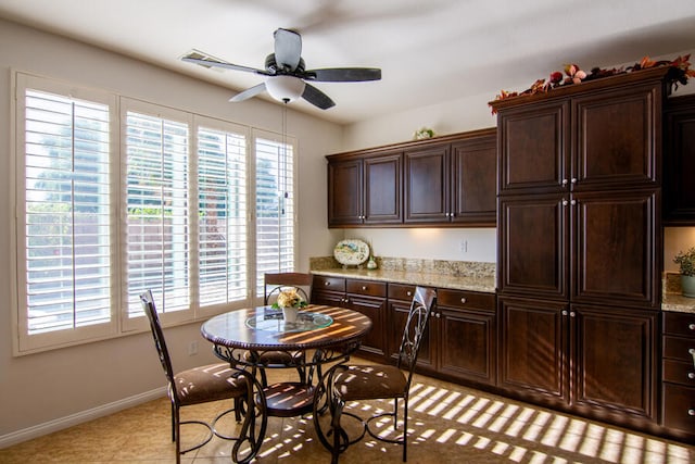 kitchen featuring dark brown cabinetry, a wealth of natural light, and light stone counters