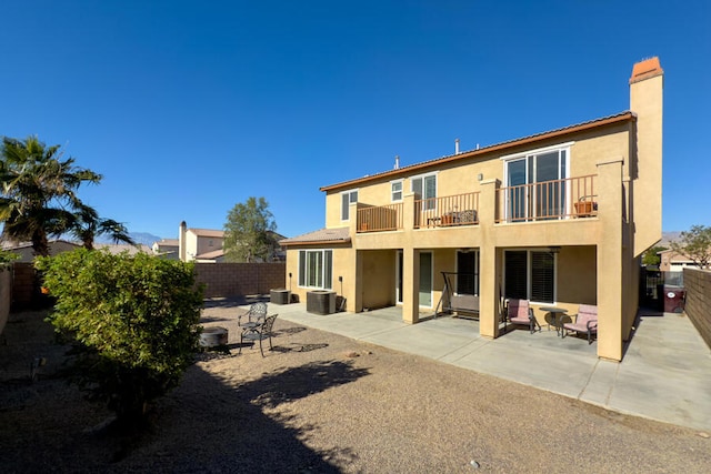 rear view of house with a patio, a balcony, and cooling unit