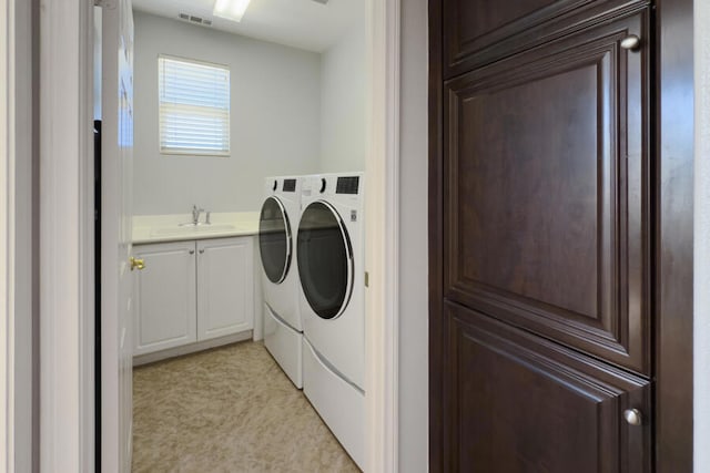 laundry room featuring washer and dryer, cabinets, and sink