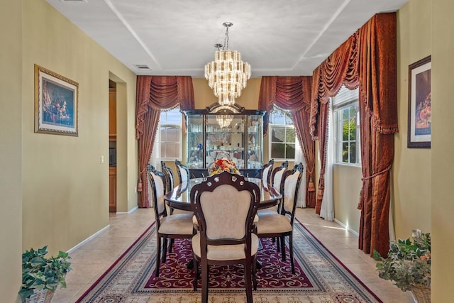 tiled dining room featuring a notable chandelier