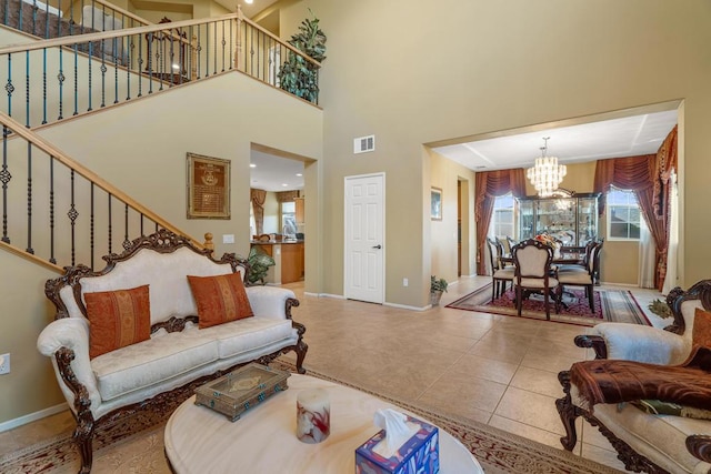 living room featuring tile patterned flooring, a towering ceiling, and an inviting chandelier