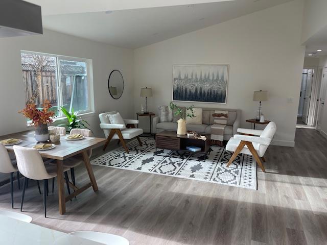 living room featuring wood-type flooring and lofted ceiling