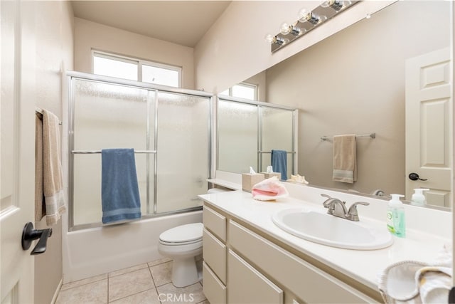 full bathroom featuring toilet, vanity, tile patterned flooring, and shower / bath combination with glass door