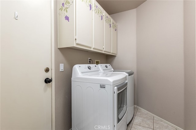 laundry room featuring light tile patterned floors, washer and dryer, and cabinets