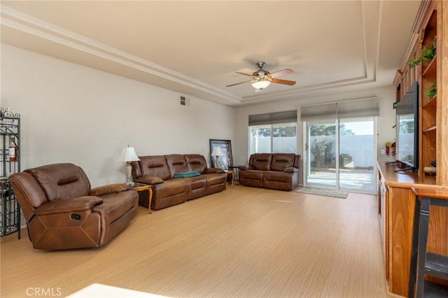 living room featuring ceiling fan, hardwood / wood-style floors, and a raised ceiling