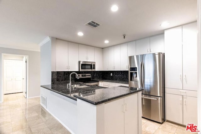 kitchen featuring sink, kitchen peninsula, dark stone counters, appliances with stainless steel finishes, and ornamental molding