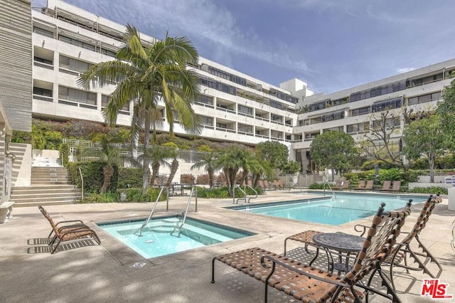 view of pool with a patio and a hot tub