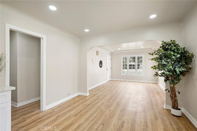 interior space with arched walkways, recessed lighting, baseboards, and light wood-style floors