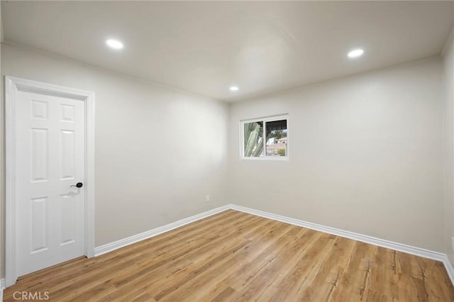 empty room with light wood-style floors, recessed lighting, ornamental molding, and baseboards