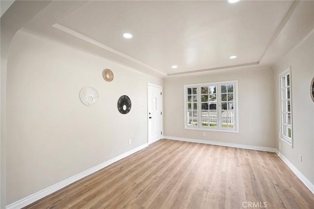 spare room featuring light wood-type flooring, baseboards, and recessed lighting