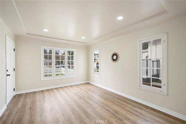 empty room with recessed lighting, light wood finished floors, and baseboards