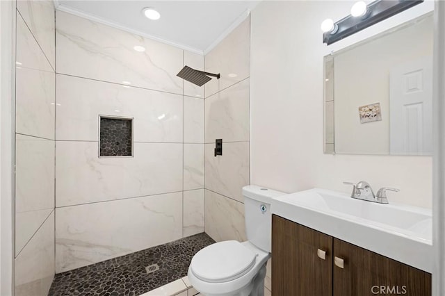 full bath featuring ornamental molding, a tile shower, vanity, and toilet