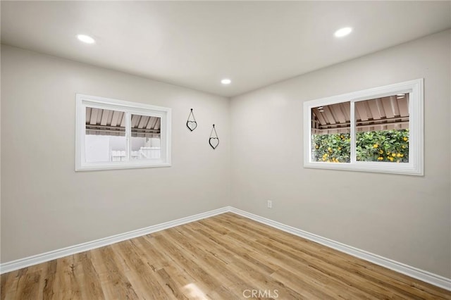 spare room with light wood-type flooring, baseboards, and recessed lighting