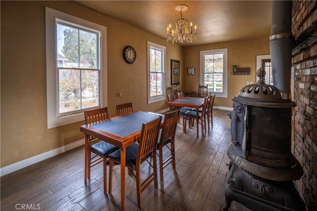 dining space featuring a wood stove, plenty of natural light, and dark wood-type flooring