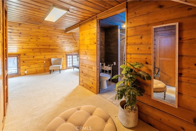 interior space with wood walls, light colored carpet, and wood ceiling