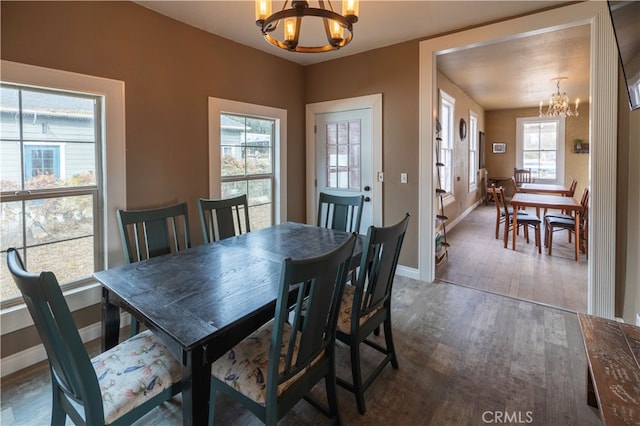 dining space with dark hardwood / wood-style floors and an inviting chandelier