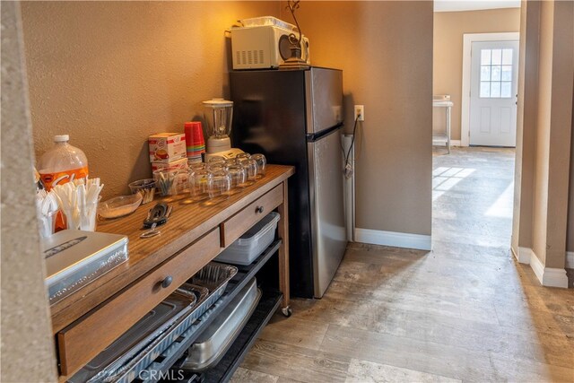 kitchen with wooden counters and stainless steel refrigerator