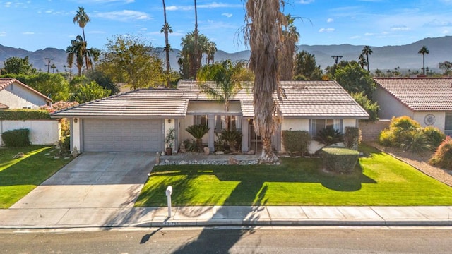 single story home featuring a mountain view, a garage, and a front yard