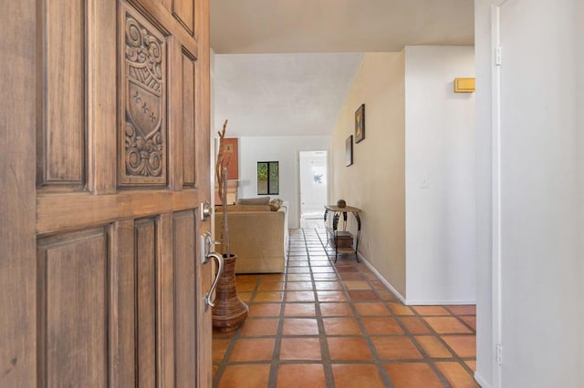 foyer with tile patterned flooring and lofted ceiling