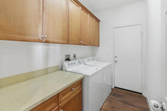 clothes washing area featuring separate washer and dryer, dark hardwood / wood-style flooring, and cabinets