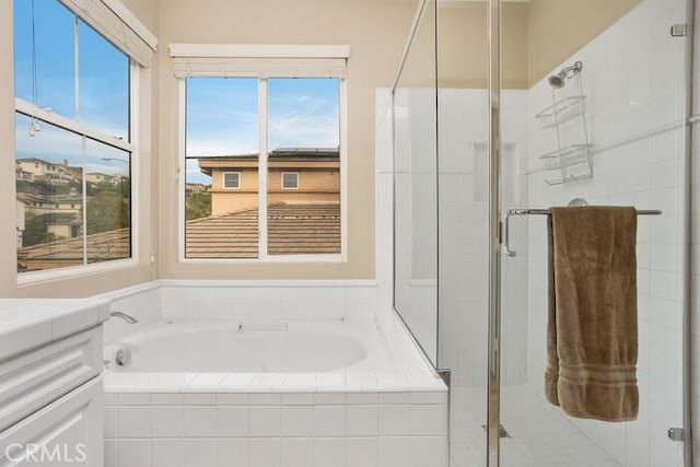 bathroom featuring vanity and independent shower and bath