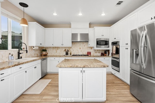 kitchen featuring sink, stainless steel appliances, extractor fan, light stone countertops, and a kitchen island