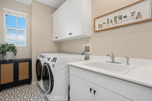 washroom featuring light tile patterned flooring, cabinets, washer and clothes dryer, and sink