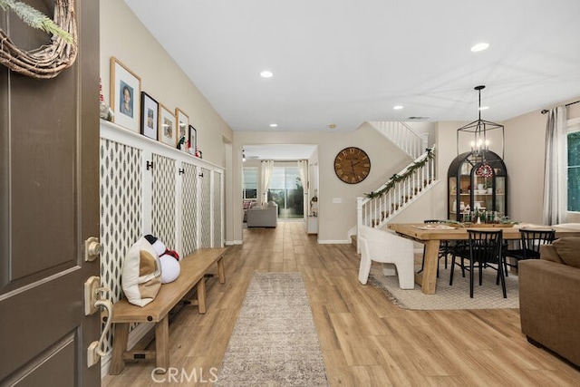 interior space with a wealth of natural light, a notable chandelier, and light wood-type flooring