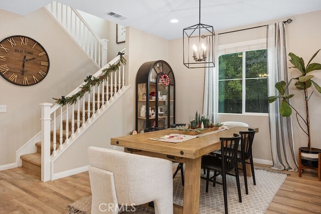 dining area with an inviting chandelier and light wood-type flooring