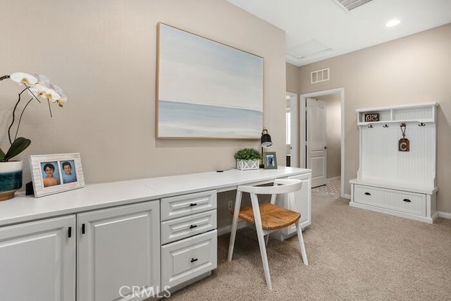 office with built in desk and light colored carpet