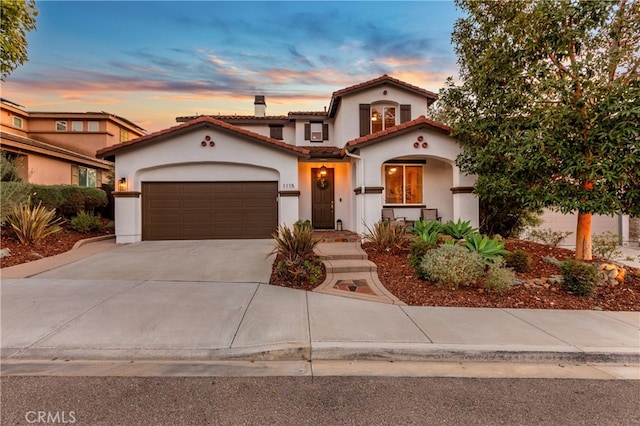 mediterranean / spanish-style house with a garage