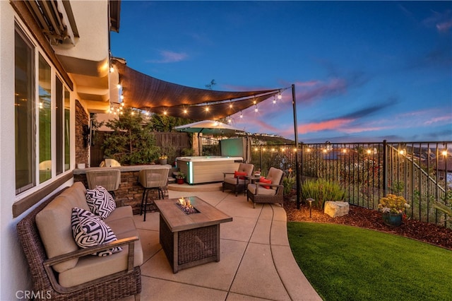 patio terrace at dusk featuring a hot tub, an outdoor bar, and an outdoor living space with a fire pit