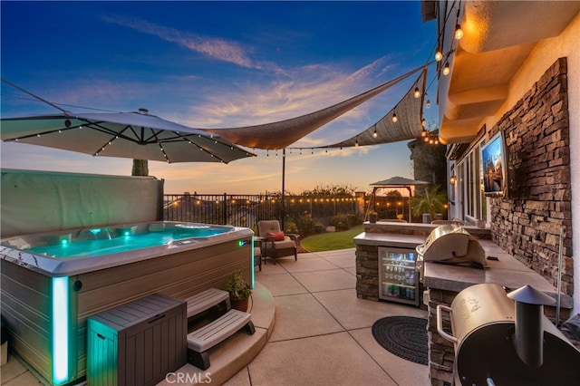 view of patio / terrace featuring a gazebo, an outdoor kitchen, and a hot tub