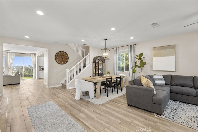 living room featuring a chandelier and light wood-type flooring