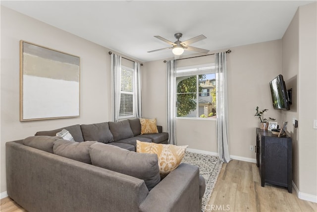 living room with light hardwood / wood-style flooring and ceiling fan