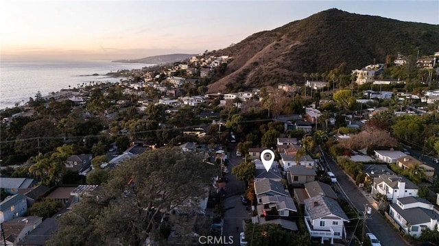 aerial view at dusk featuring a water and mountain view