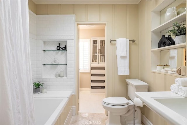 bathroom featuring a bathing tub, tile patterned flooring, and toilet