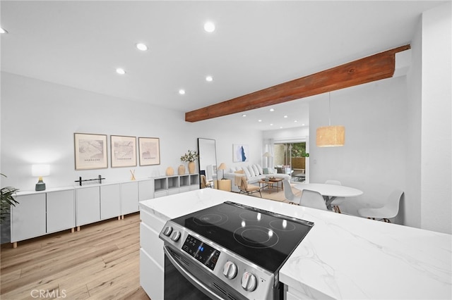 kitchen featuring light hardwood / wood-style flooring, white cabinetry, light stone counters, stainless steel range with electric cooktop, and beamed ceiling