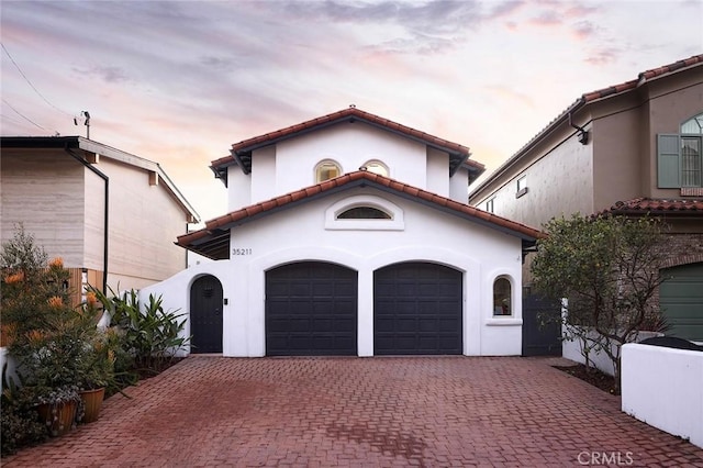 mediterranean / spanish-style house with a garage