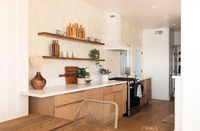 kitchen featuring range with gas stovetop, decorative backsplash, hardwood / wood-style floors, and extractor fan